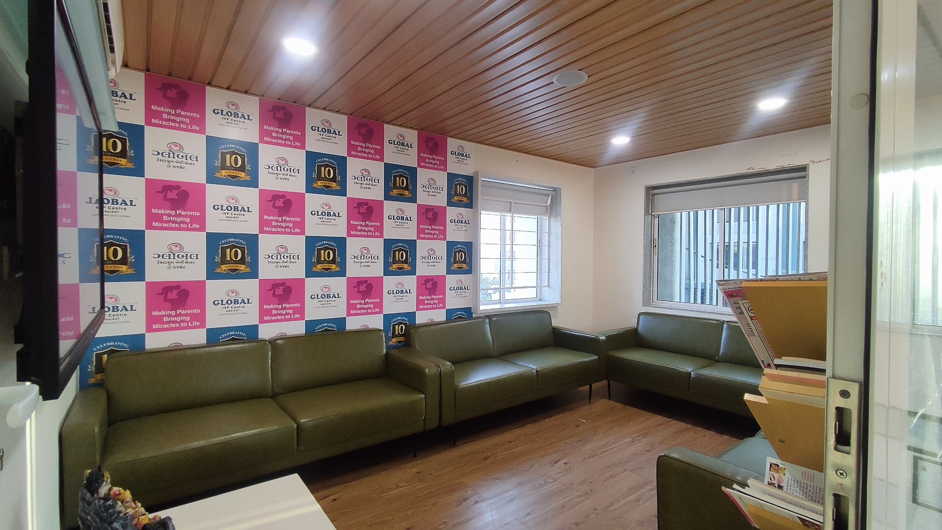 Second-floor waiting area with branded backdrop wall at Global IVF Centre Rajkot