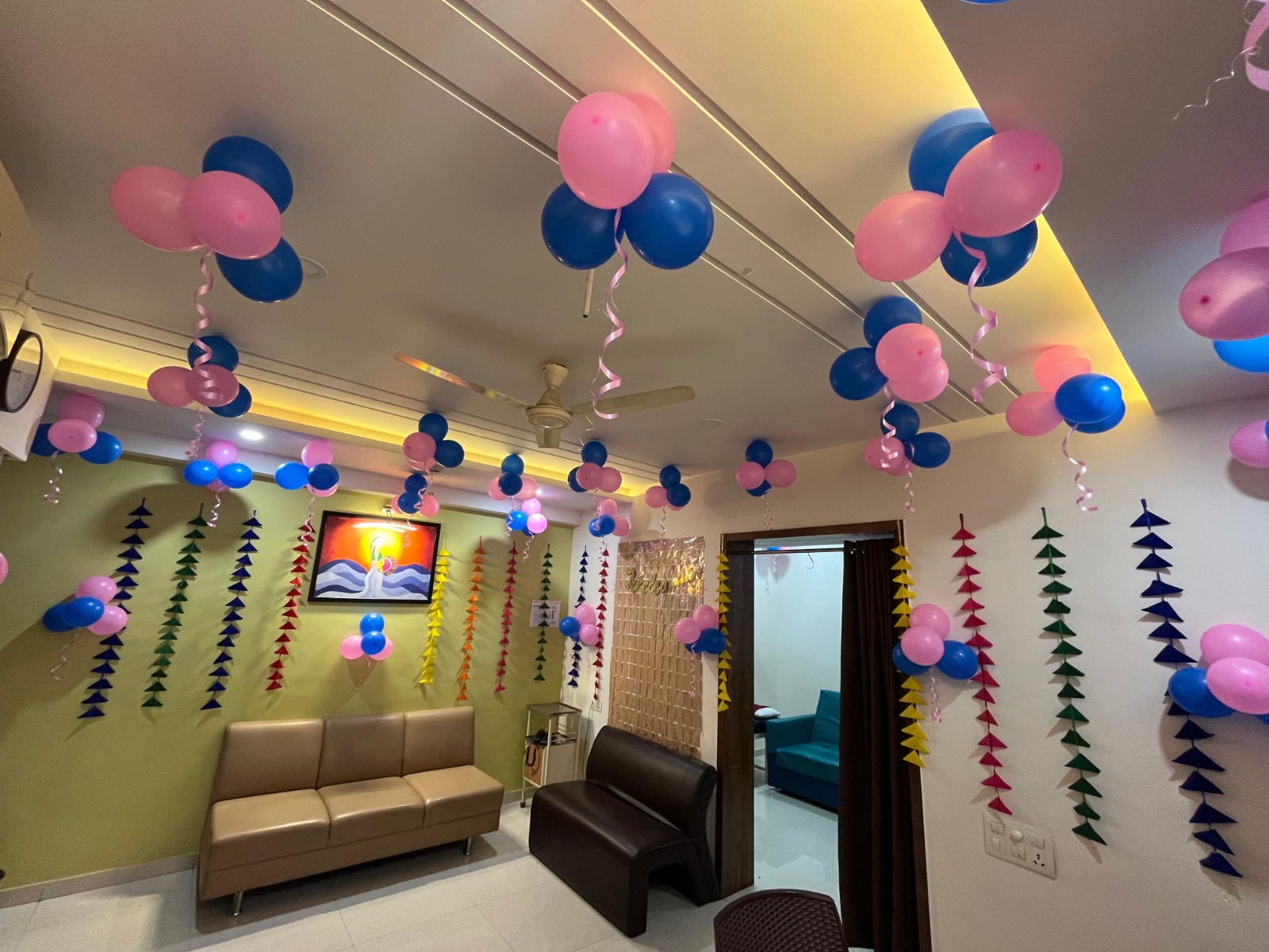 Consultation lounge decorated with pink and blue balloons for a positive pregnancy announcement